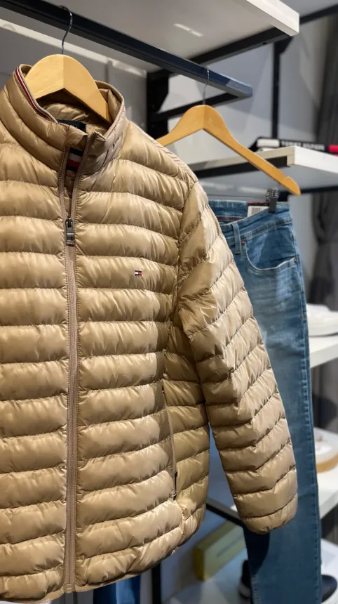 Jaqueta puffer Tommy Hilfiger no cabide, interior da Majoy Centro