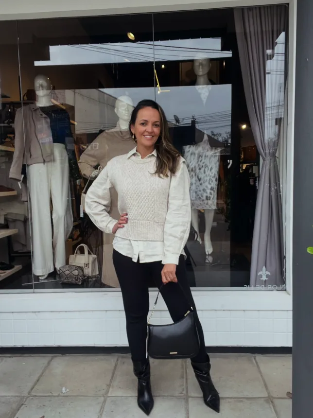 Look com camisa de linho e colete de tricô em frente à vitrine da Majoy Centro